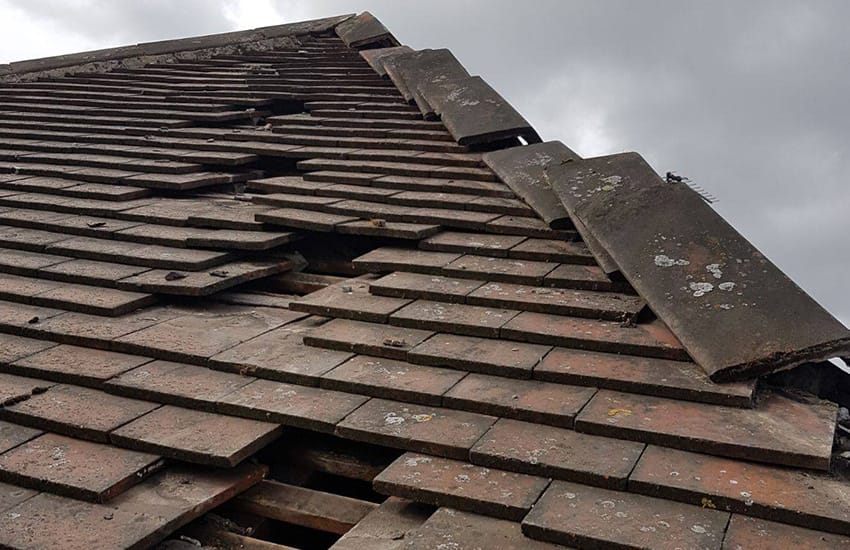 Roof tilers Adelaide - tile roofer replacing cracked and slipped roof tiles on a terracotta roof in Adelaide